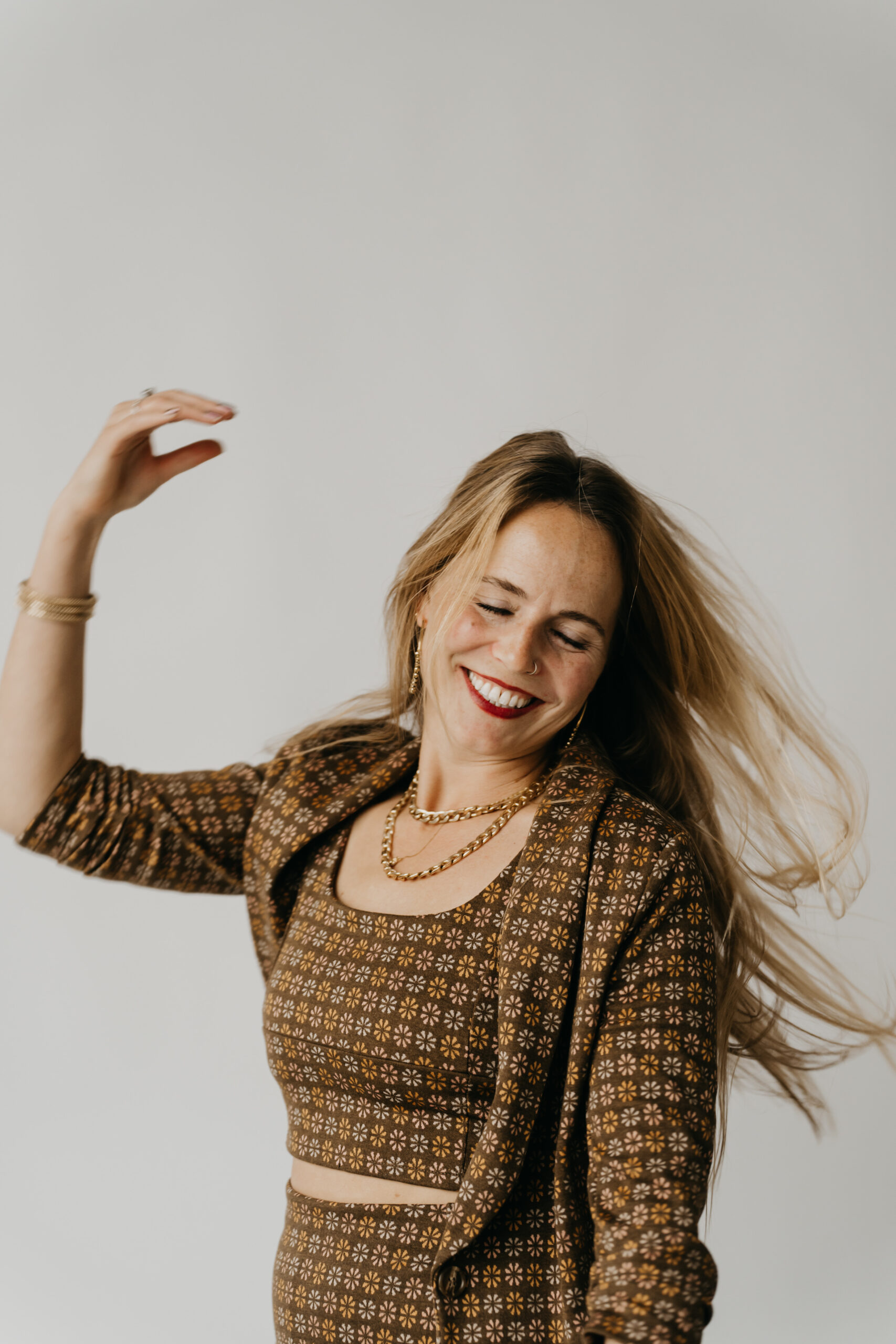 Creative entrepreneur celebrating success and building wealth as a photographer during a joyful studio photoshoot