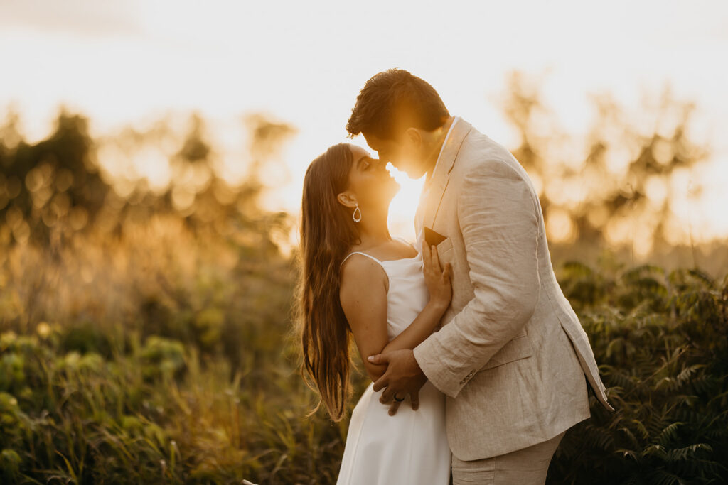 Bride and groom silhouetted against a golden sunset in an open field, romantic Minnesota wedding photography