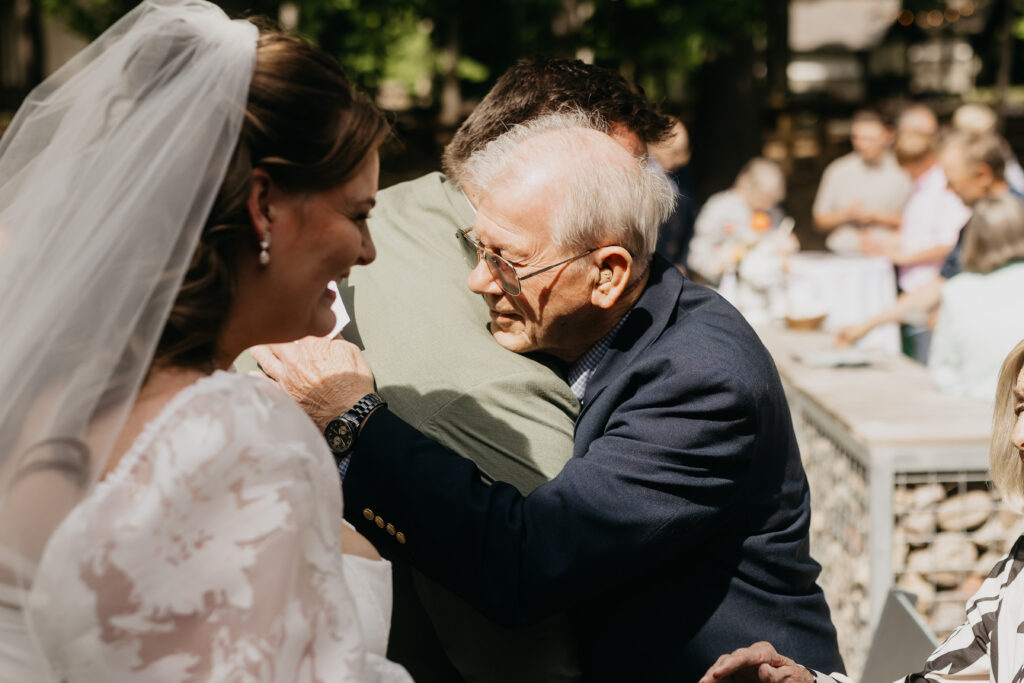 Elderly grandfather emotional at his grandchild's outdoor wedding ceremony in Minnesota
