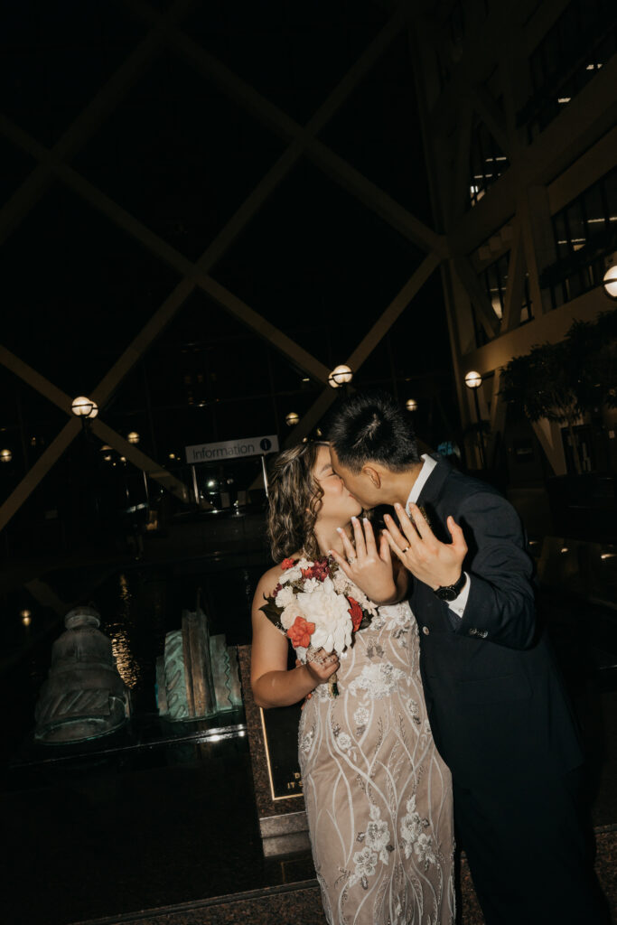Bride and groom sharing a kiss at night inside a downtown Minneapolis venue, wedding photography by Mycah Bain