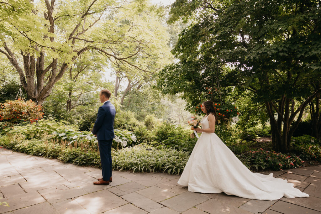 Groom turning to see bride for the first time during first look in a garden, Minneapolis wedding photographer