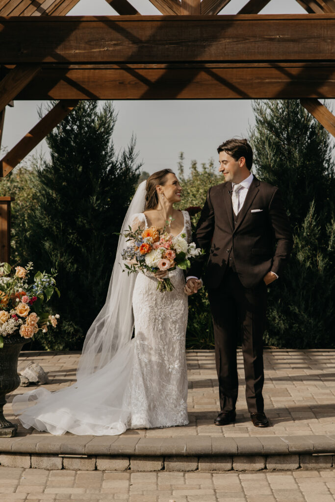 Bride and groom standing at the altar under a timber pergola at a Minnesota outdoor wedding venue