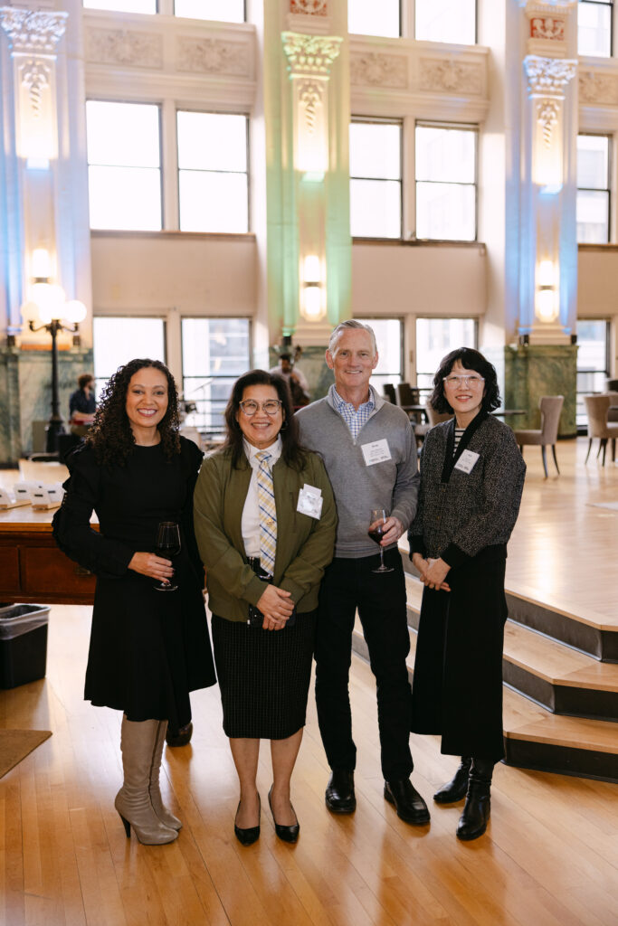 Three MPR corporate event guests posing together inside the Minneapolis Grain Exchange — corporate event photography by Mycah Bain Photography