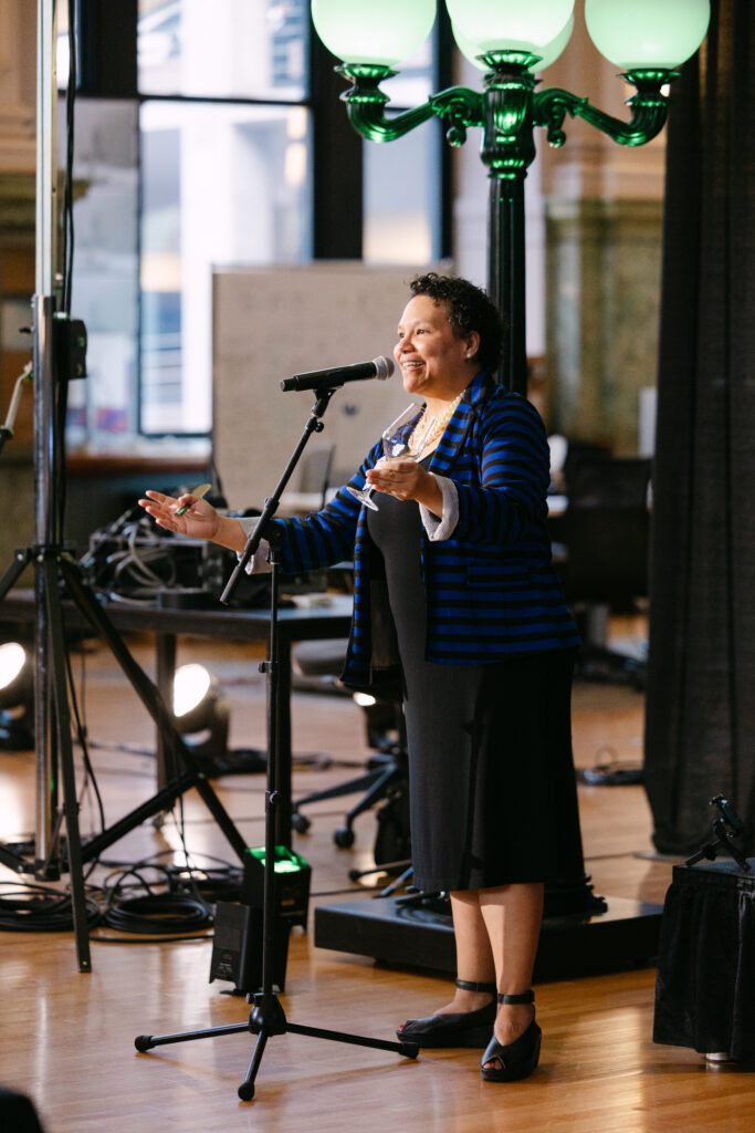 MPR speaker presenting at microphone on stage inside the Minneapolis Grain Exchange during corporate gala — Minneapolis corporate event photographer