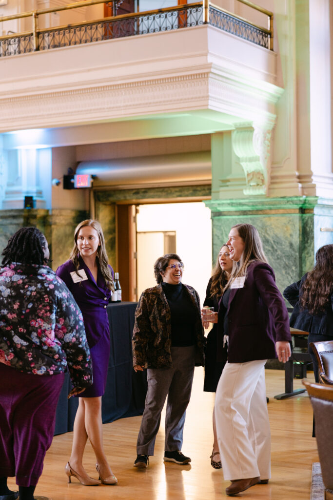 MPR corporate event guests networking in the grand hall of the Minneapolis Grain Exchange with ornate columns and arched windows