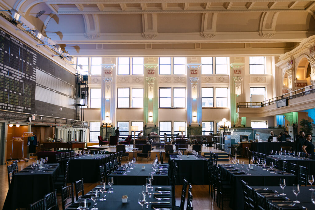 Minneapolis Grain Exchange coffered ceiling and ornate columns with corporate event dinner setup below — Minneapolis corporate event photographer Mycah Bain Photography