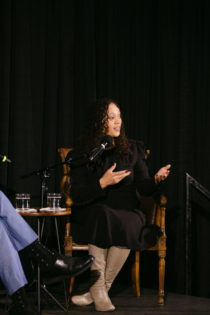 MPR speaker in black dress presenting on stage at the Minneapolis Grain Exchange corporate event — Minneapolis corporate event photographer Mycah Bain Photography
