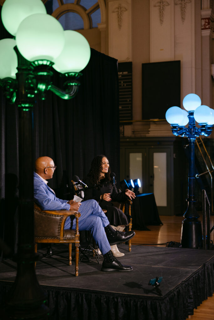 Two MPR speakers on stage with glowing globe lights at the Minneapolis Grain Exchange corporate gala — corporate event photography Minneapolis by Mycah Bain Photography