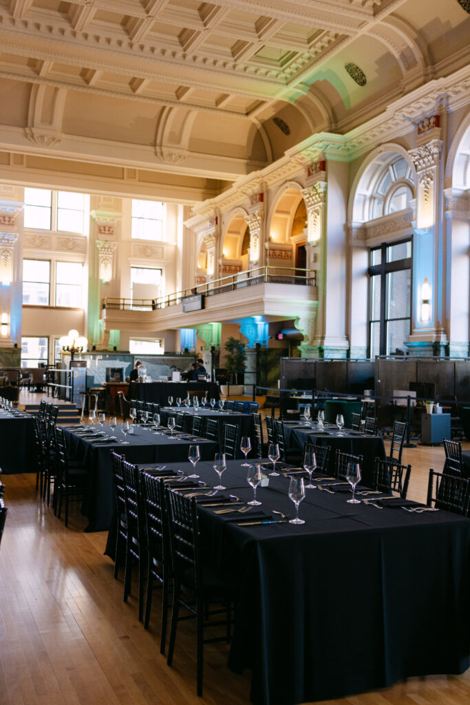 Minneapolis Grain Exchange corporate event dinner tables with arched windows and ornate architecture — MPR gala photography by Mycah Bain Photography