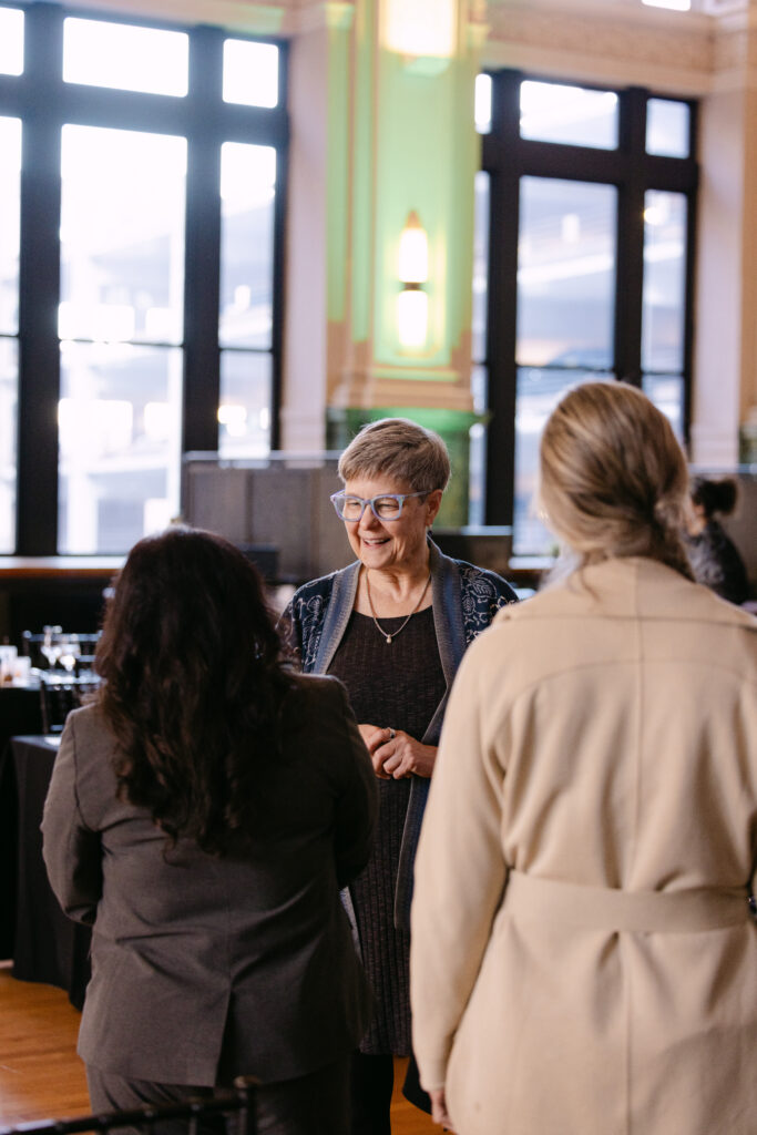 Minnesota Public Radio gala guests in conversation inside the Minneapolis Grain Exchange historic trading floor — corporate event photography Minneapolis