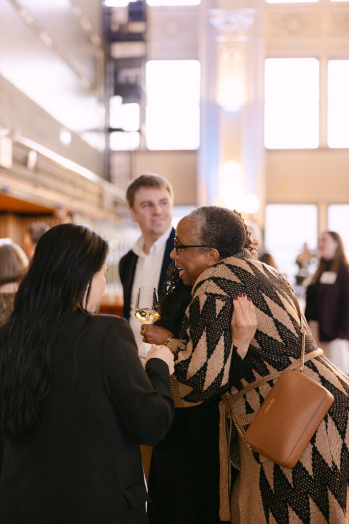 MPR corporate event guests greeting each other warmly during cocktail hour at the Minneapolis Grain Exchange — Mycah Bain Photography