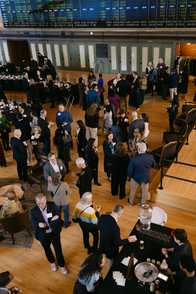 Overhead view of Minnesota Public Radio gala guests mingling on the historic Minneapolis Grain Exchange trading floor — Minneapolis corporate event photographer