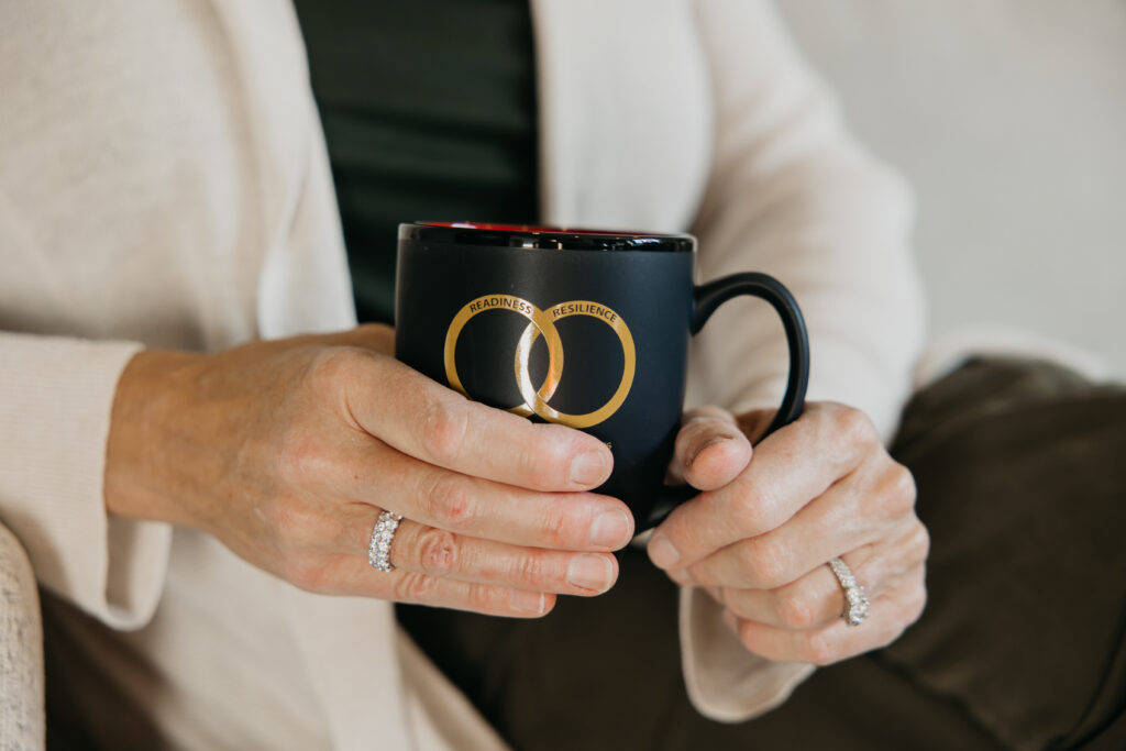 Close-up of hands holding RINGS ARMOR research program mug — branded B-roll detail from Minneapolis psychologist brand photography session