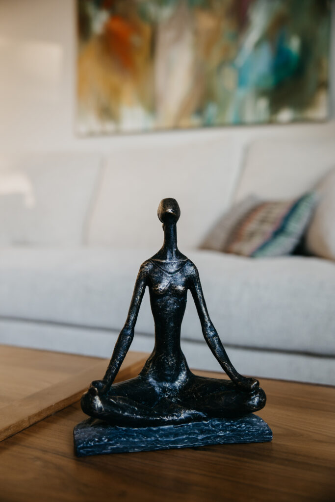 Meditation figure sculpture on coffee table — B-roll detail from brand photography psychologist Minneapolis session by Mycah Bain Photography