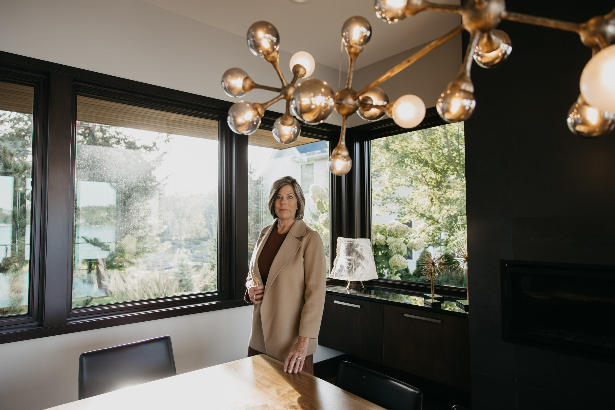 Dr. Melissa Polusny board-certified psychologist standing at conference table during brand photography session in Mound Minnesota by Mycah Bain Photography