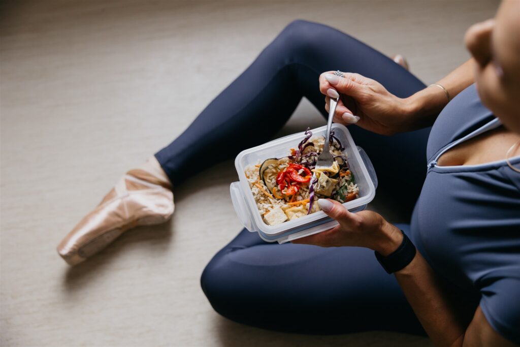 Close-up of Lili Pfeifer of The Barbell Ballerina holding colorful meal prep bowl — nutrition coaching B-roll from fitness brand photography Minneapolis session