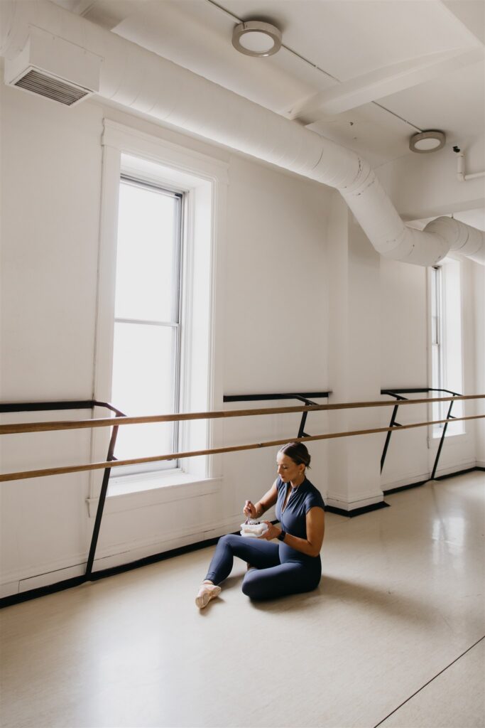Lili Pfeifer of The Barbell Ballerina seated on studio floor eating from a bowl during nutrition coaching fitness brand photography Minneapolis session
