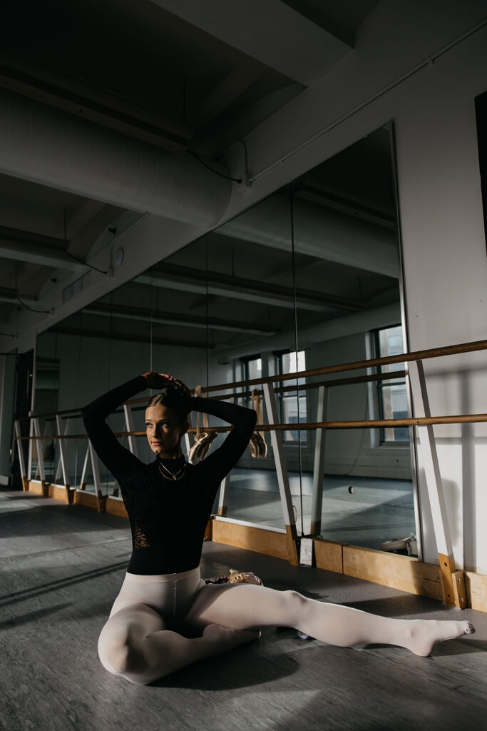 Lili Pfeifer of The Barbell Ballerina in a middle split at the barre in a dance studio during fitness brand photography Minneapolis session by Mycah Bain Photography