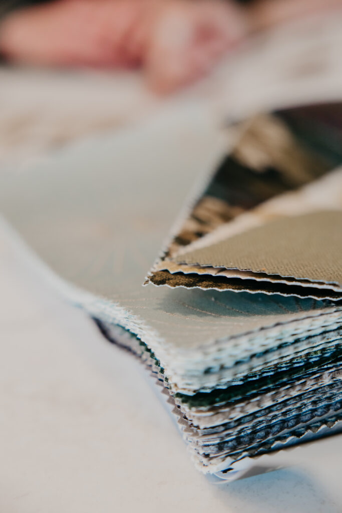 Close-up of folded fabric swatches in coordinating neutral tones for custom window treatment selection