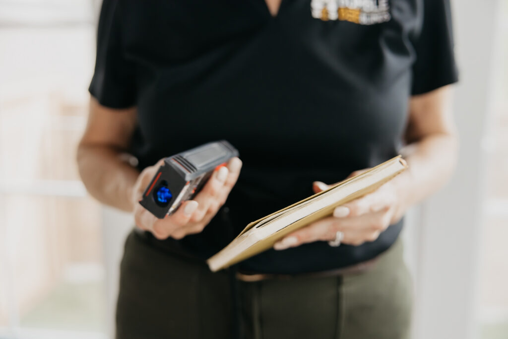 Close-up of hands holding a credit card reader and a binder during a client consultation
