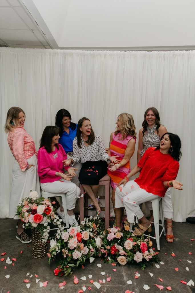 Haute House Studio team smiling and reacting to falling flower petals during brand photography session in Edina Minnesota by Mycah Bain Photography