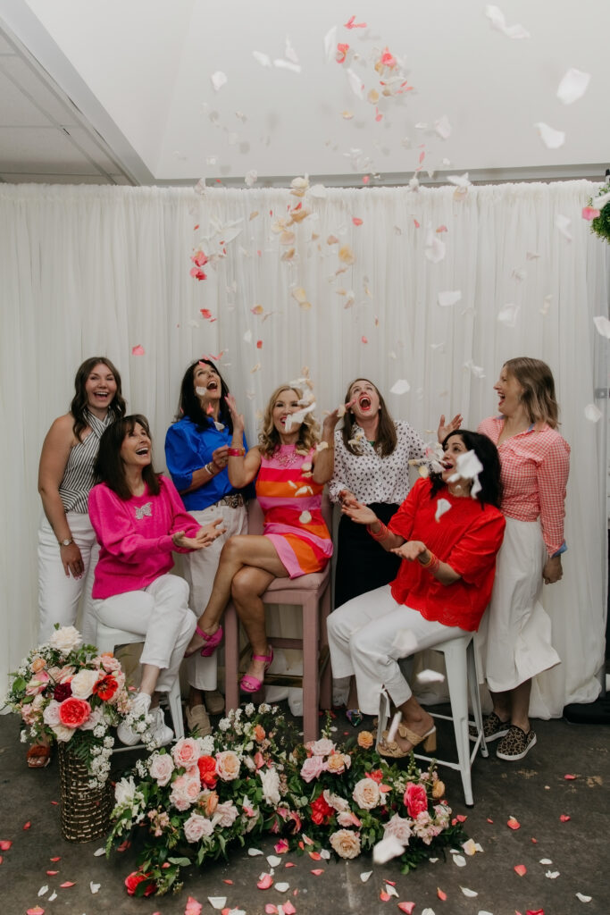 Haute House Studio team laughing as flower petals fall from above during a confetti petal moment in their brand photography session