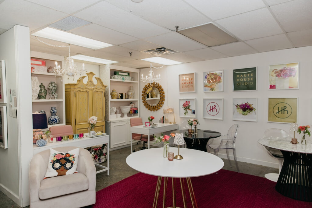 Wide shot of the Haute House Studio interior in Edina MN showing gallery wall branded artwork white tables and styled decor