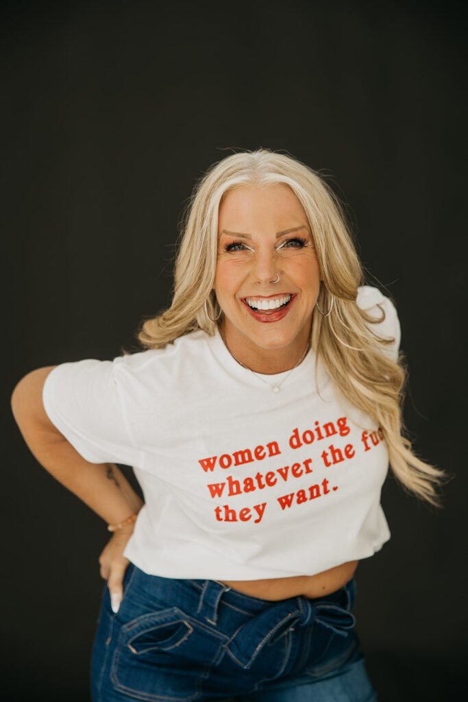 Women's wellness coach smiling in a feminist graphic tee during bold Minneapolis brand photo shoot