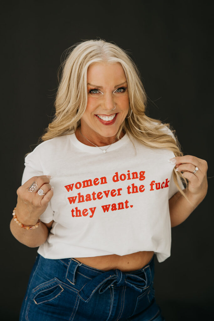Women's mentor in statement tee and jeans posing confidently during brand photography session
