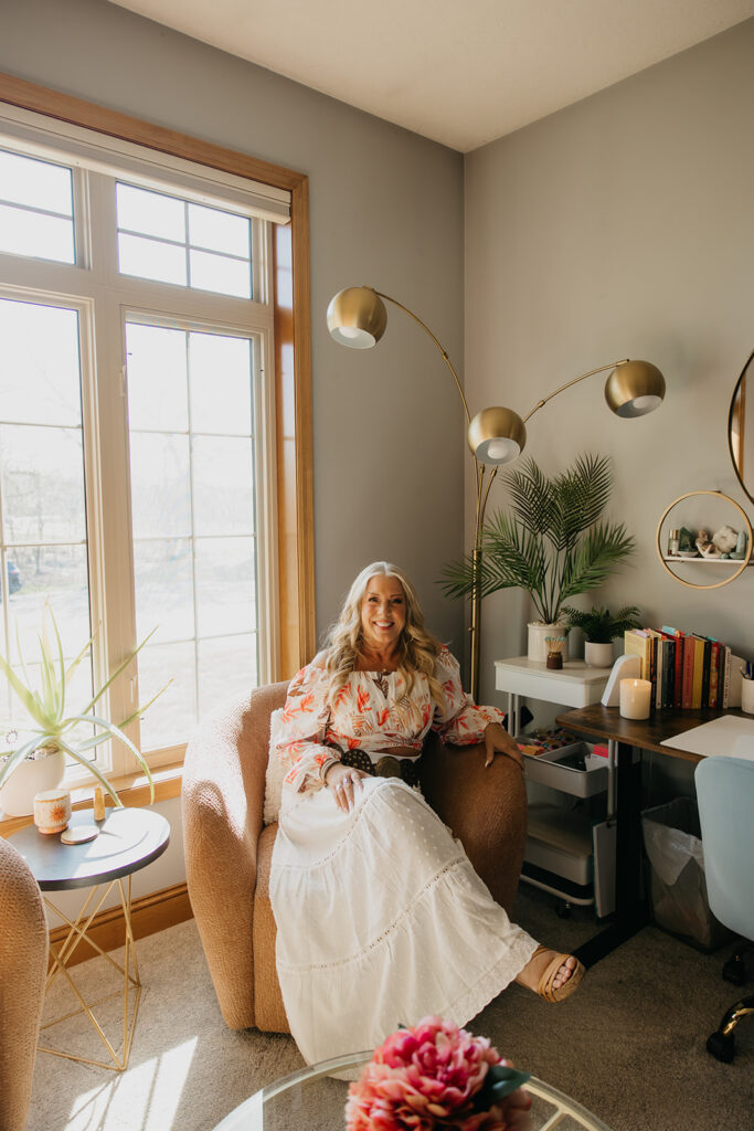 Full-length portrait of women's mentor seated in a stylish home office during brand photography session