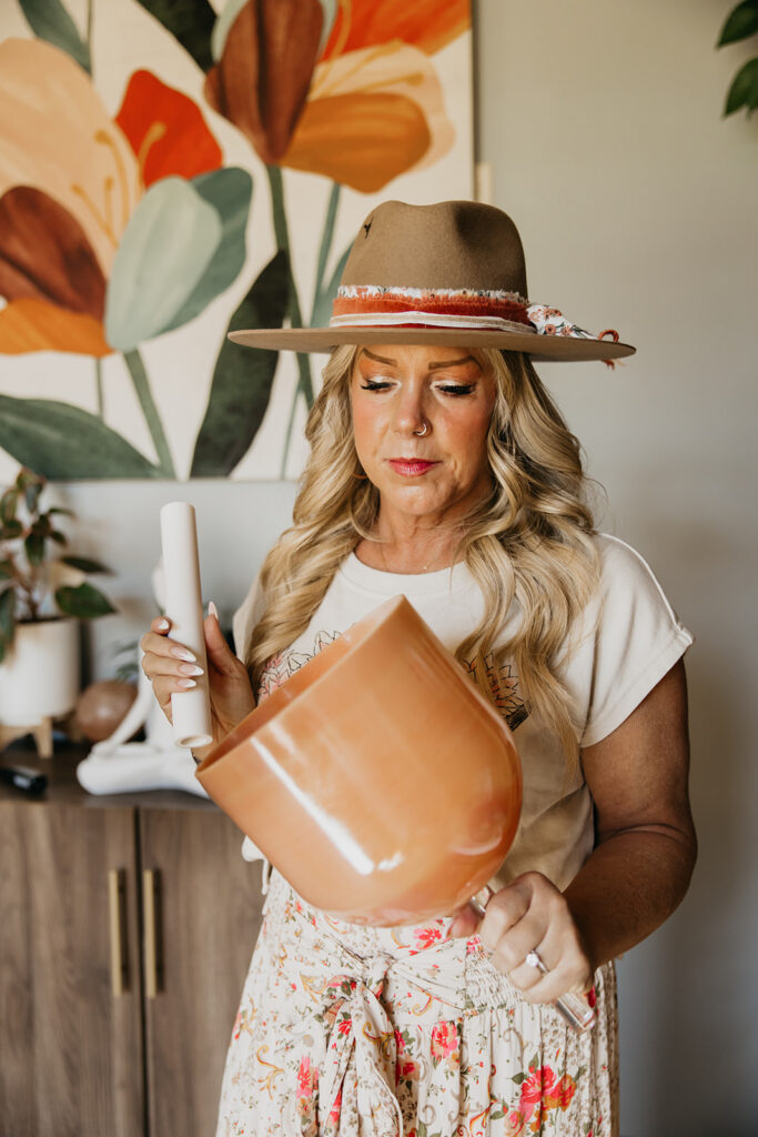 Women's energy healer looking down at a copper singing bowl during brand photography session in Minneapolis
