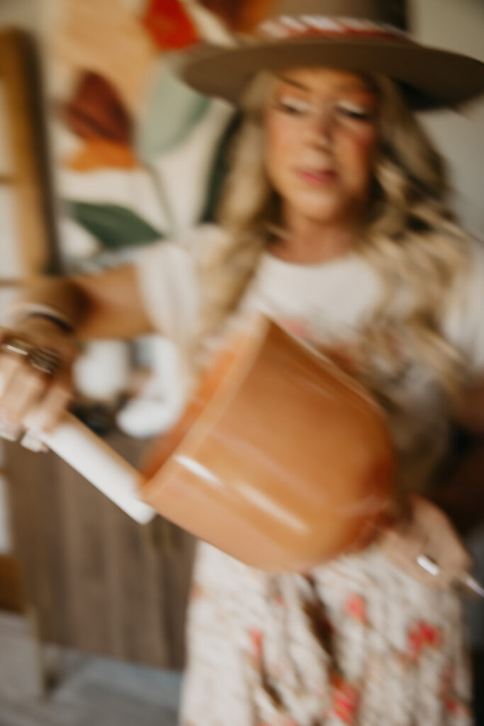 Motion-blur action shot of women's wellness coach spinning a singing bowl during brand photo shoot