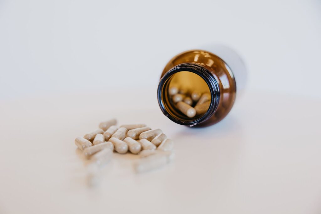 Supplement capsules spilling from amber bottle during MIMC brand photography Minneapolis