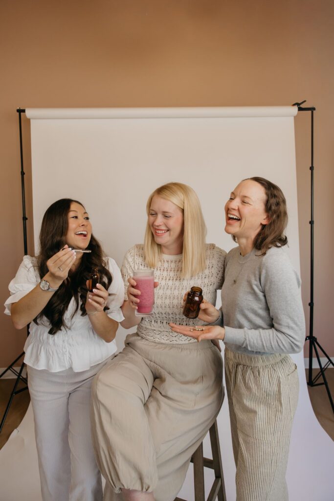 MIMC team holding wellness drinks and laughing during integrative medicine brand photography Minneapolis