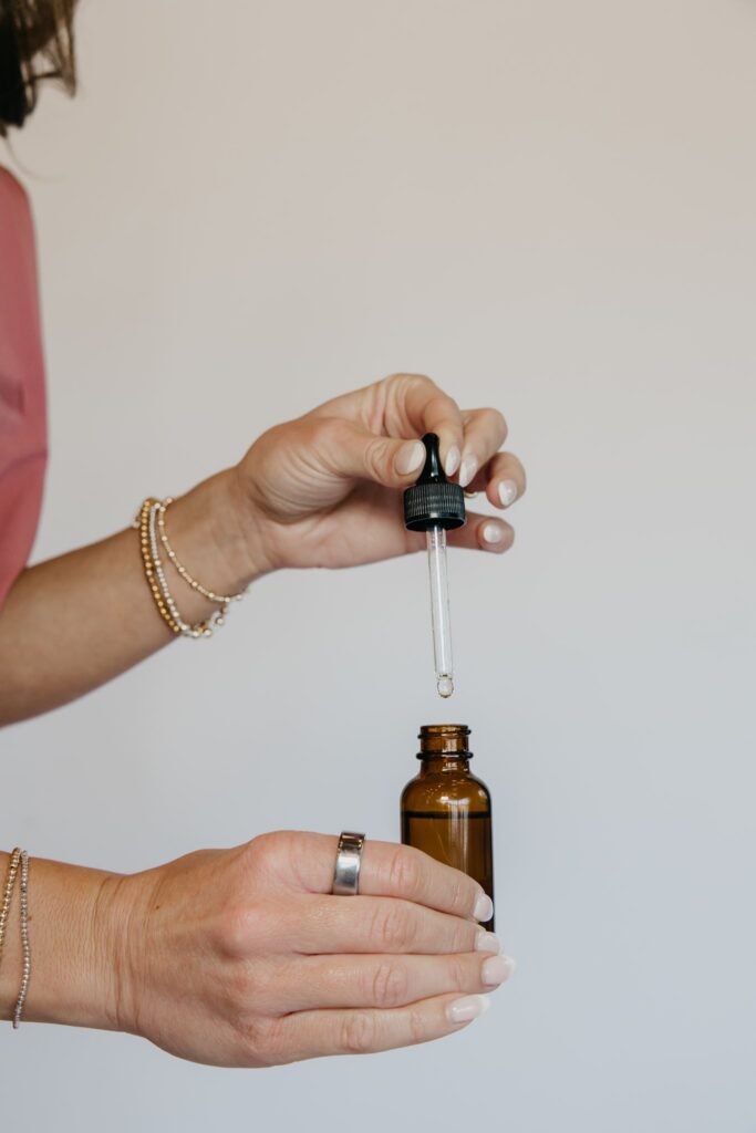 Hand dropping tincture from amber bottle during MIMC healthcare brand photography Minneapolis