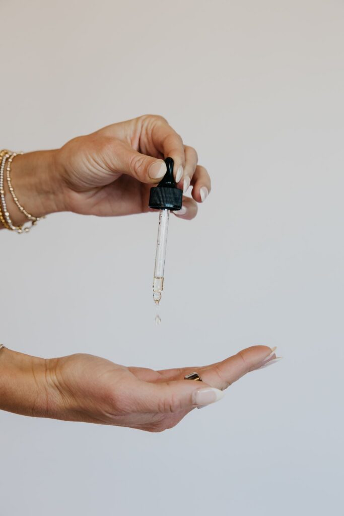 Hand holding tincture dropper during integrative medicine brand photography session Minneapolis