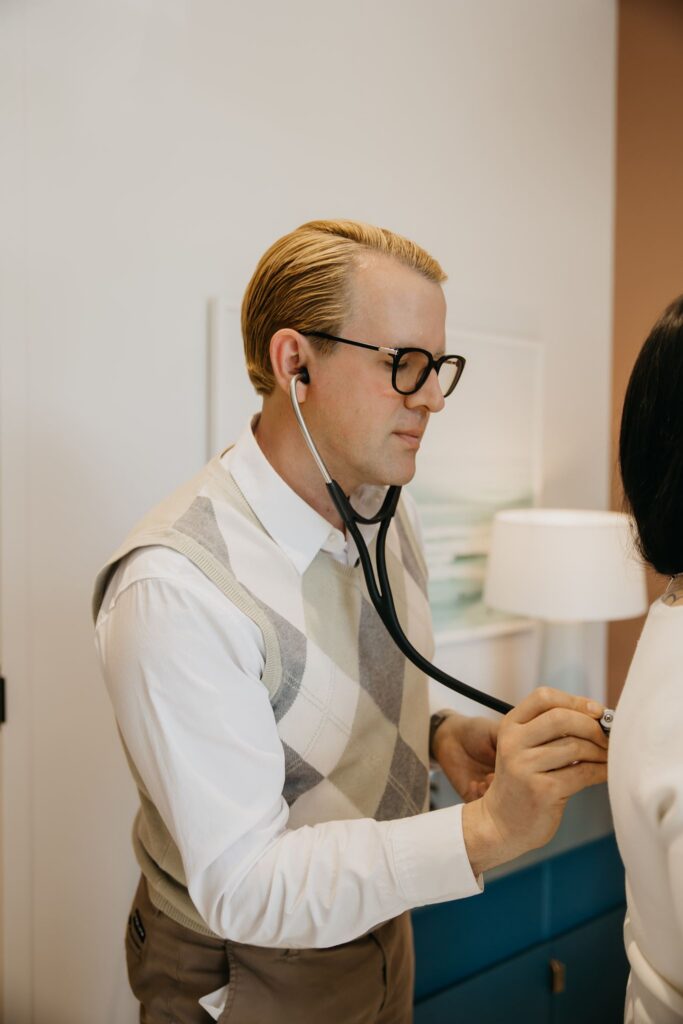 MIMC doctor using stethoscope with patient during healthcare brand photography session Minneapolis