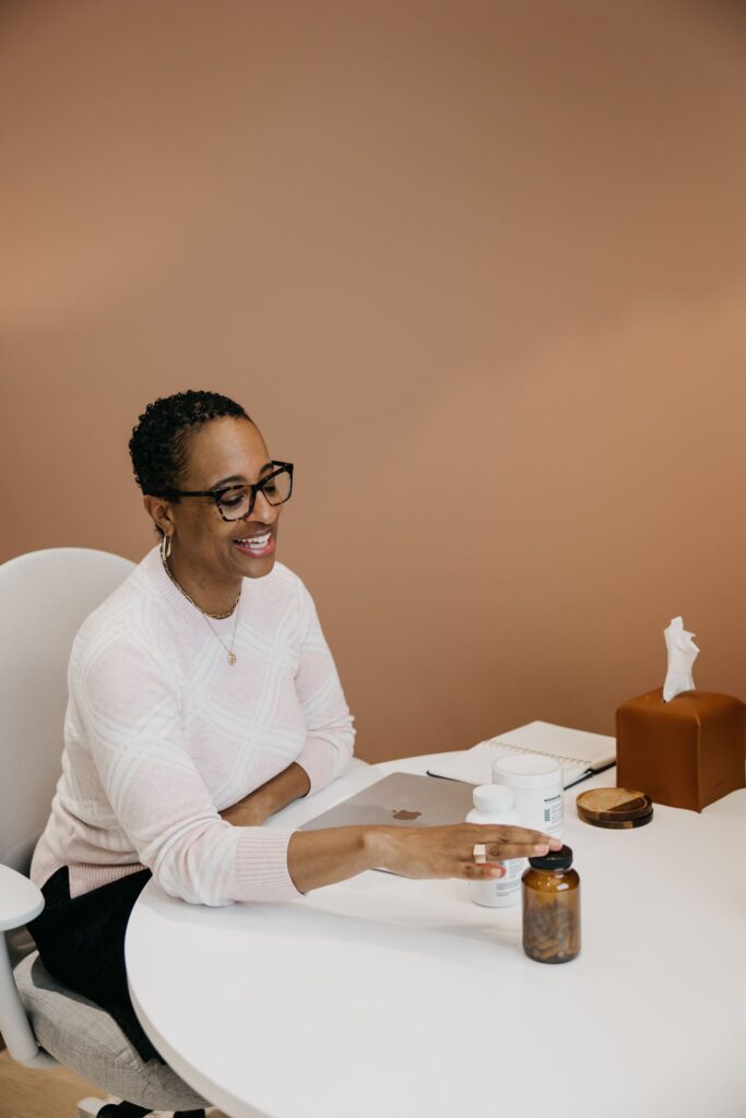 MIMC integrative medicine provider seated at consultation desk during brand photography Minneapolis