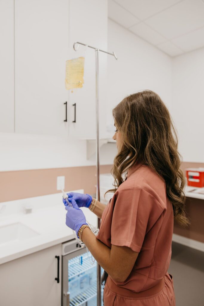 MIMC nurse preparing IV bag in infusion room during brand photography Minneapolis