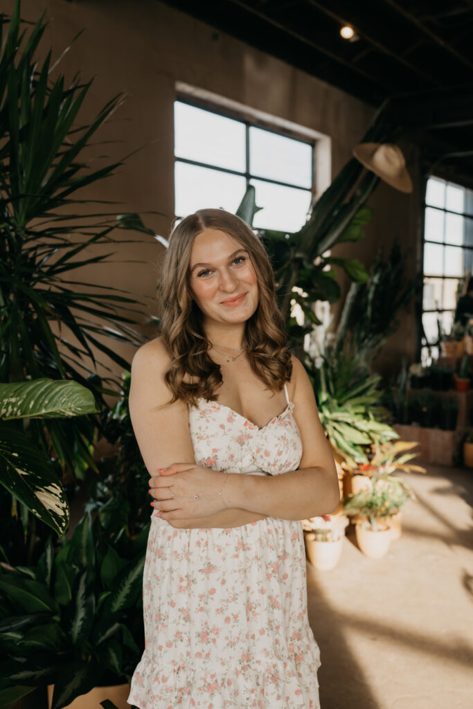 Hopkins senior photos of girl in floral dress standing with arms crossed at Minneapolis plant shop