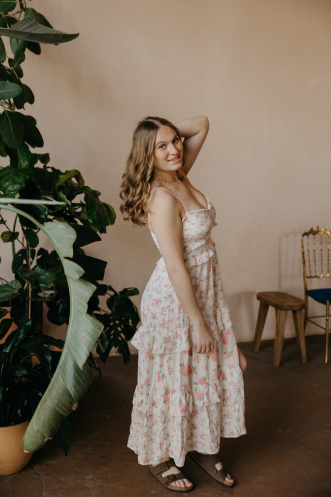 Hopkins High School senior girl in floral maxi dress hand in hair side profile at Minneapolis plant shop