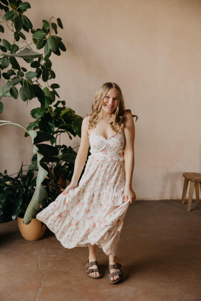 Hopkins High School senior girl in floral maxi dress swishing skirt at Minneapolis plant shop