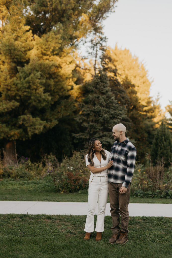 Couple embracing on a garden path lined with fall foliage