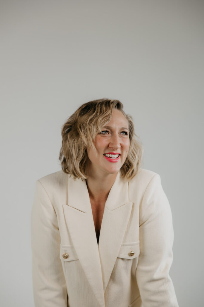 Headshot-style brand photography for transformational coaches, Dr. Mel Krug smiling in a cream blazer