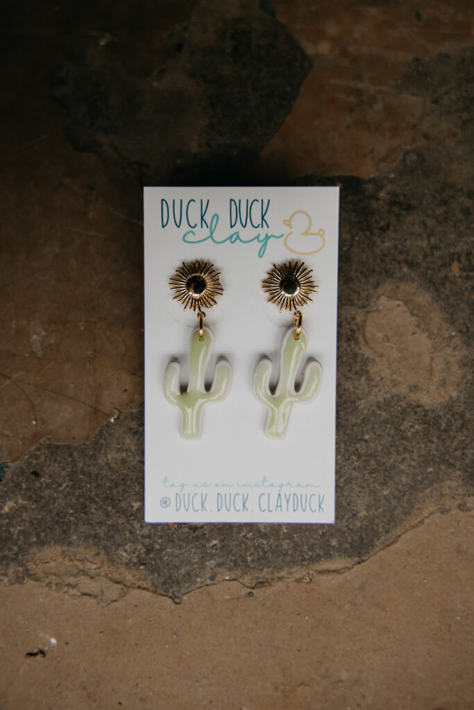 Cactus-shaped earrings displayed on a branded card, product photography for Duck Duck Clay Duck