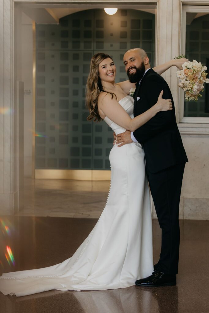 Bride and groom embrace in a full-length rooftop portrait