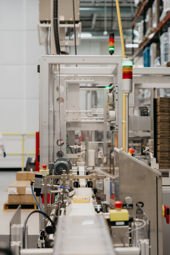 Close-up of pharmaceutical packaging conveyor equipment with safety indicator lights