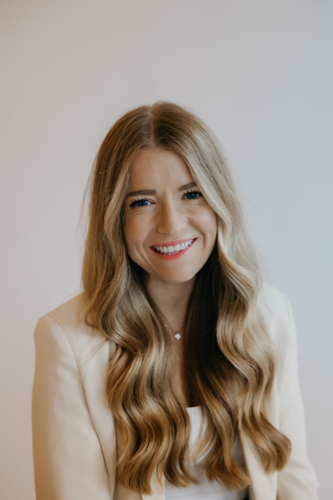 Close-up portrait of content creator smiling in cream blazer, brand photography headshot