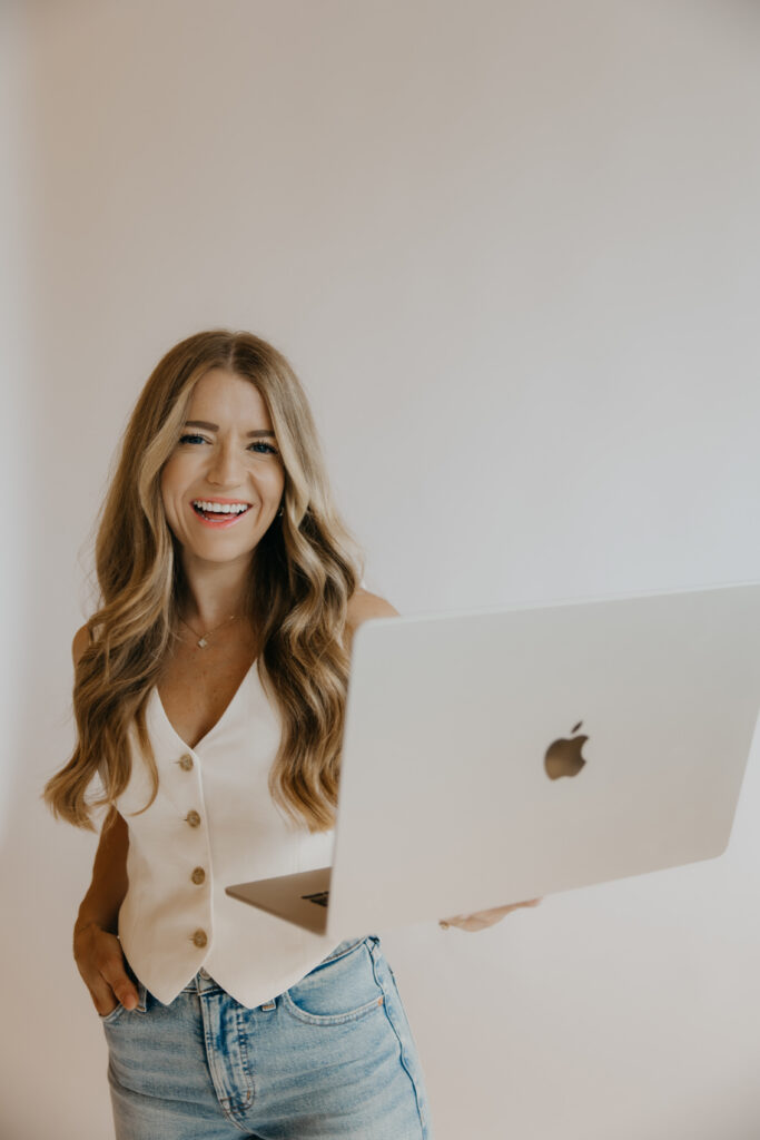 Content creator laughing while holding open laptop, brand photography for content creators
