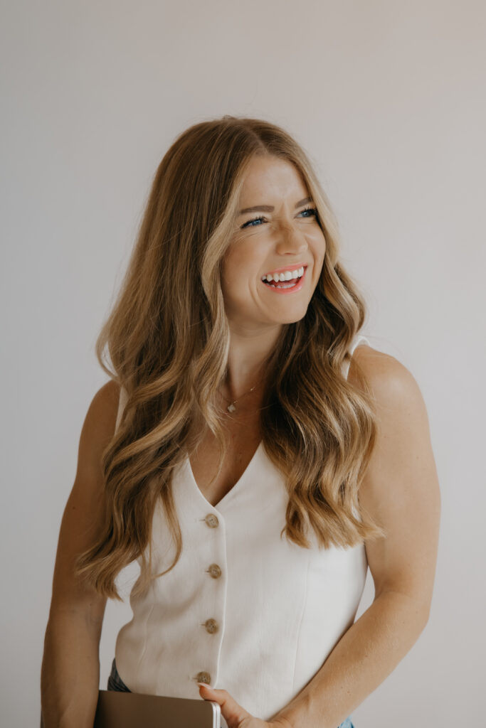 Content creator smiling with hair blowing in cream button-up top